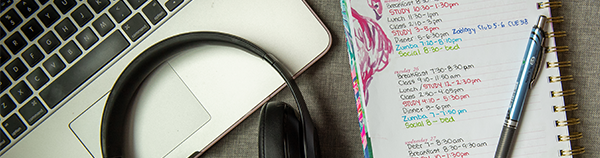 Laptop computer, headphones, notepad, and pen.